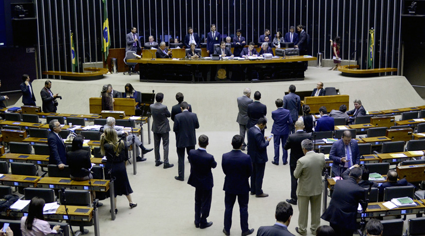#PraCegoVer a foto mostra alguns deputados de pé no plenário da câmara